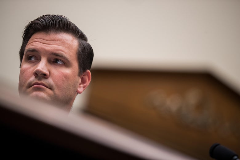 Scott Lloyd at a desk in a hearing room.